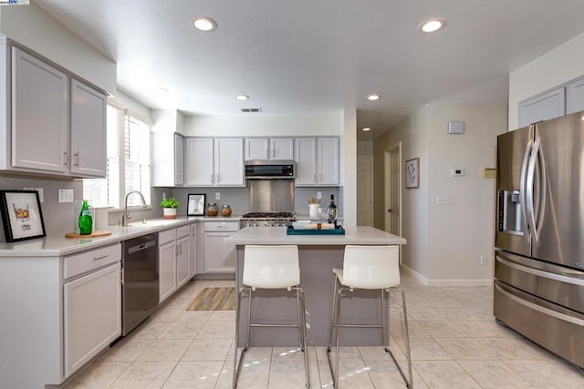 kitchen with sink, light tile patterned floors, exhaust hood, a center island, and stainless steel appliances