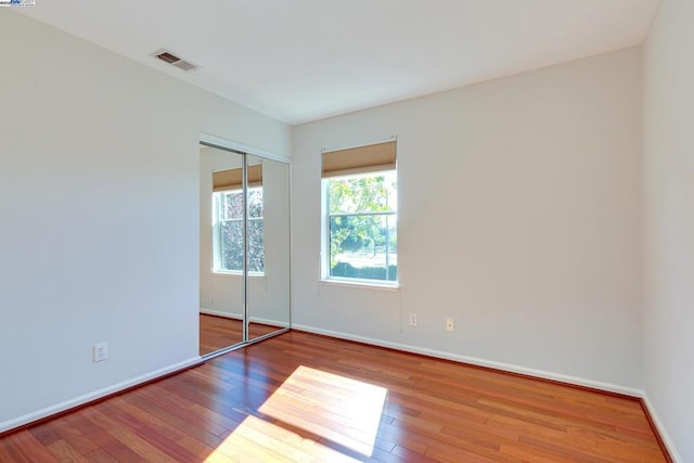 unfurnished bedroom with a closet and wood-type flooring