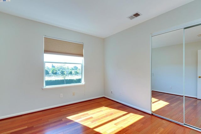 unfurnished bedroom with wood-type flooring and a closet