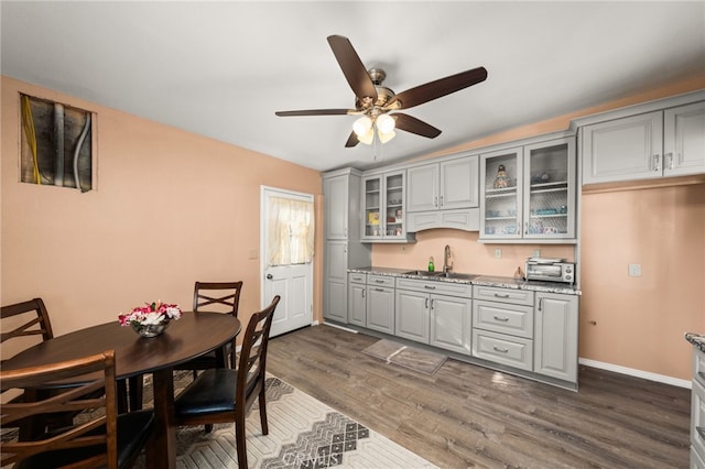 dining room featuring ceiling fan, sink, and dark hardwood / wood-style flooring