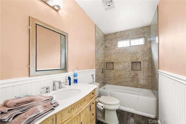 full bathroom with vanity, toilet, hardwood / wood-style floors, and tiled shower / bath combo