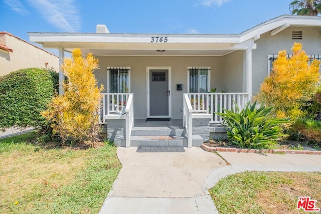 view of exterior entry with covered porch