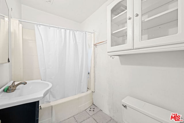 full bathroom featuring tile patterned flooring, toilet, vanity, and shower / tub combo with curtain