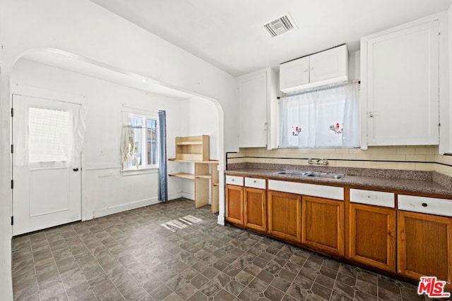 kitchen with sink, white cabinets, and tasteful backsplash