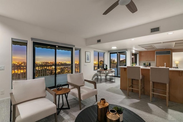 carpeted living room with ceiling fan