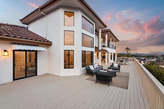 deck at dusk featuring outdoor lounge area