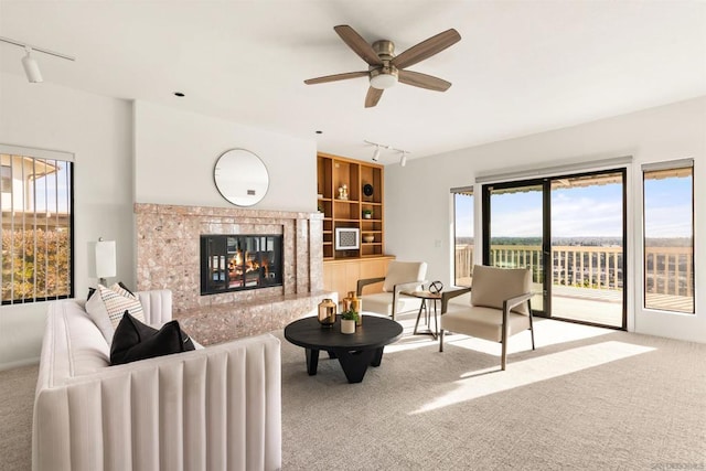 living room with track lighting, carpet flooring, a tile fireplace, and a wealth of natural light