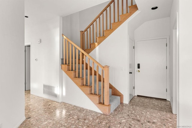 stairway featuring a towering ceiling