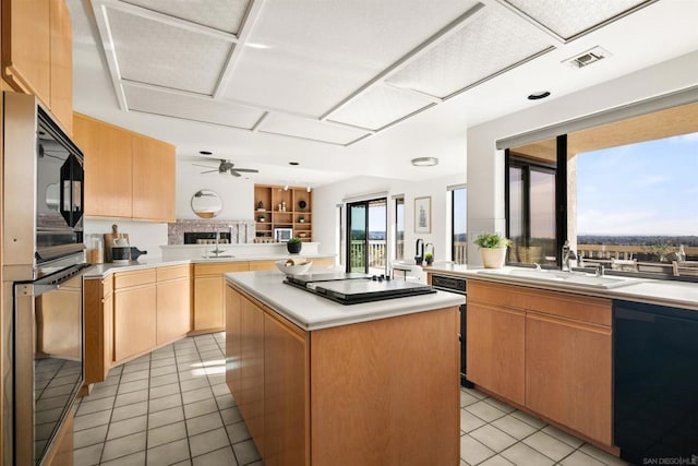 kitchen featuring sink, a center island, black appliances, light tile patterned flooring, and kitchen peninsula