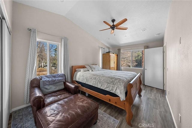 bedroom featuring lofted ceiling, multiple windows, dark hardwood / wood-style floors, and ceiling fan