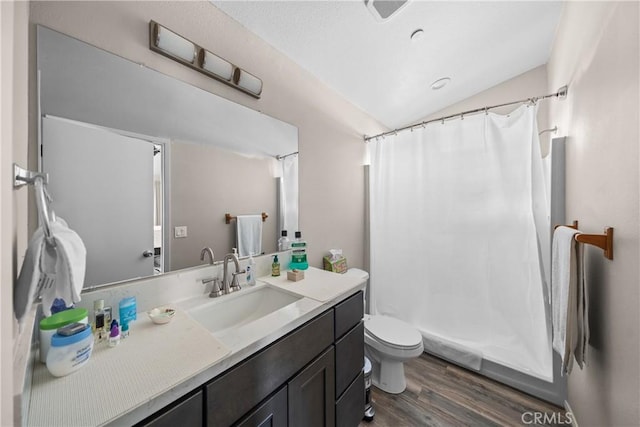 bathroom with lofted ceiling, hardwood / wood-style flooring, vanity, curtained shower, and toilet