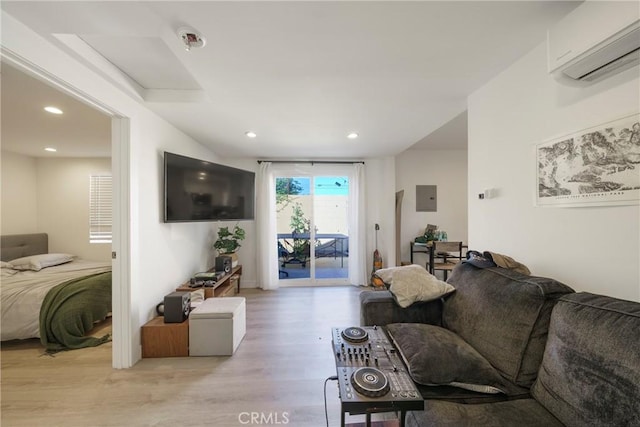 living room featuring electric panel, light hardwood / wood-style floors, and a wall unit AC