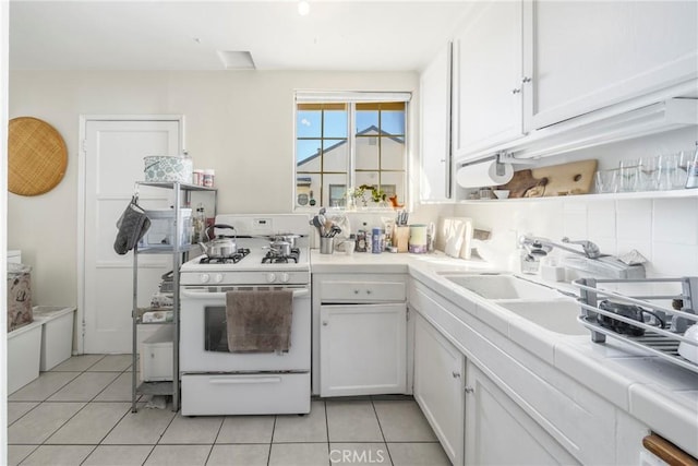 kitchen with tile counters, white cabinetry, white range with gas cooktop, and light tile patterned flooring