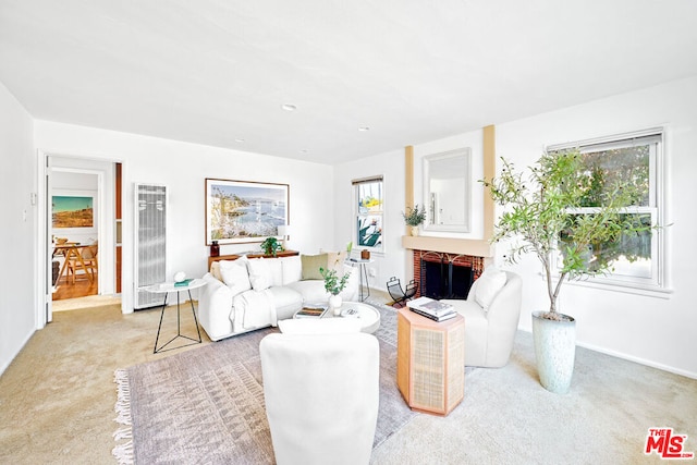 carpeted living room with a brick fireplace