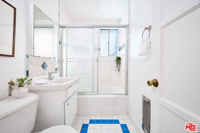 full bathroom featuring combined bath / shower with glass door, toilet, and vanity