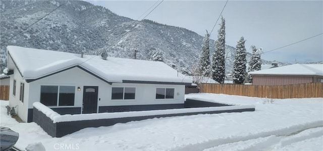 snow covered rear of property with a mountain view