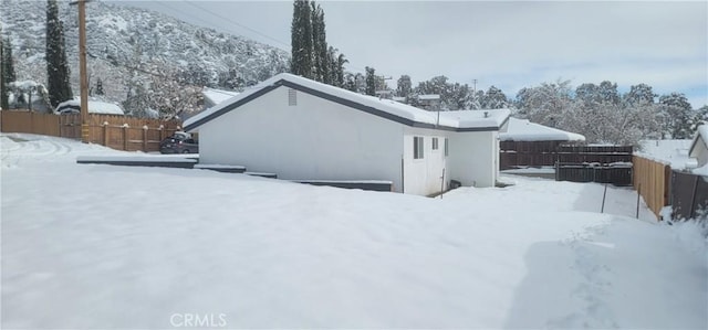 view of snow covered back of property