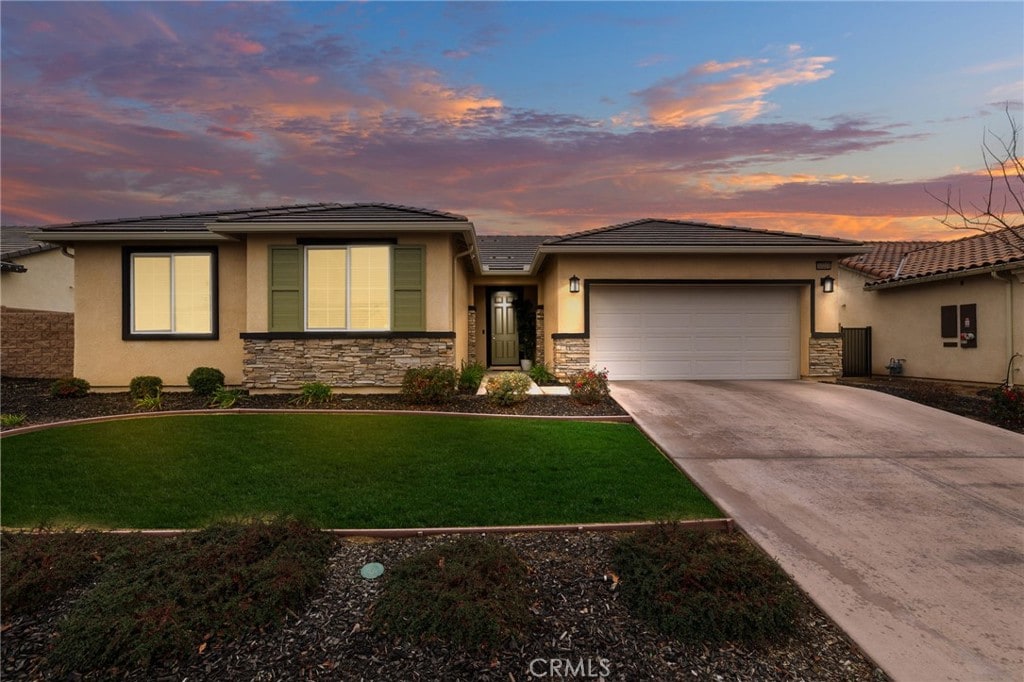 prairie-style house with a garage and a lawn