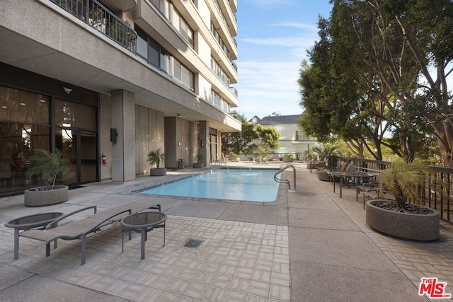 view of pool with a patio and an outdoor fire pit