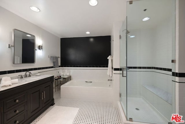 bathroom with vanity, tile walls, and separate shower and tub