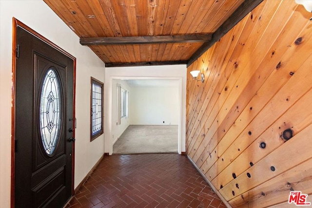 entryway featuring wooden ceiling, wood walls, and beamed ceiling