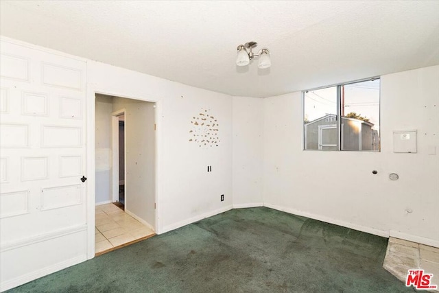 carpeted empty room featuring a textured ceiling