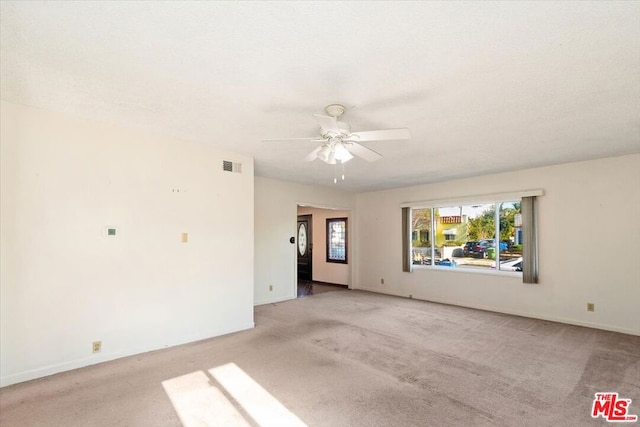 carpeted spare room with ceiling fan