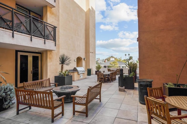 view of patio with a grill, an outdoor kitchen, and a fire pit