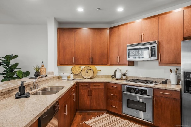 kitchen with sink, light stone counters, dark hardwood / wood-style flooring, and stainless steel appliances