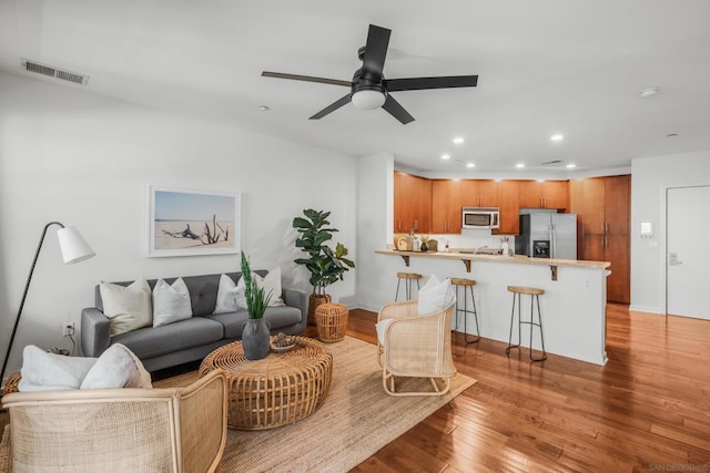 living room featuring ceiling fan and light wood-type flooring