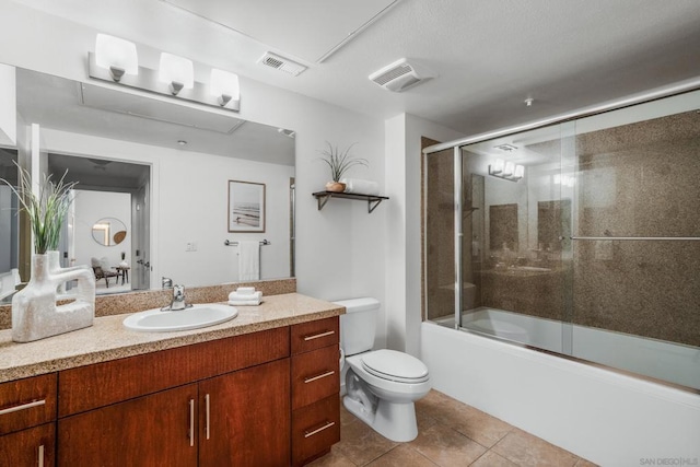 full bathroom featuring enclosed tub / shower combo, vanity, toilet, and tile patterned flooring