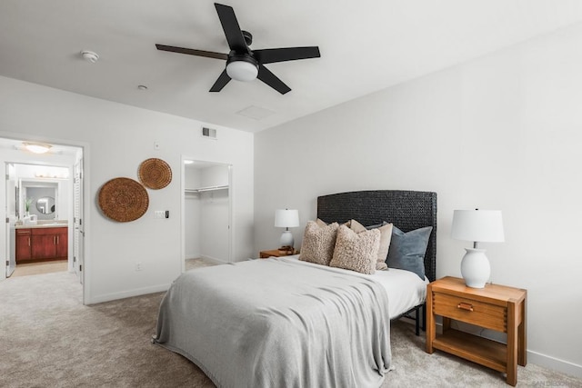 carpeted bedroom with a closet, ceiling fan, connected bathroom, and a spacious closet