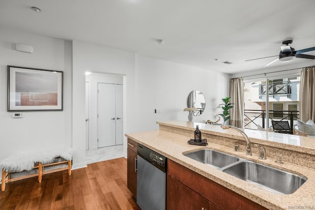 kitchen with stainless steel dishwasher, ceiling fan, sink, light stone counters, and dark hardwood / wood-style floors