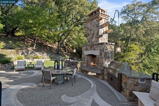 view of patio / terrace featuring sink, an outdoor stone fireplace, an outdoor kitchen, and grilling area