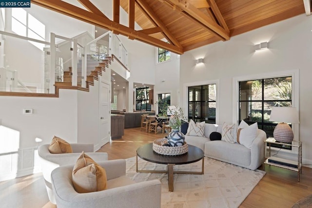 living room featuring wooden ceiling, light wood-type flooring, high vaulted ceiling, and a wealth of natural light