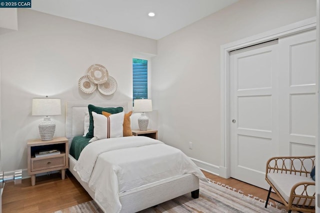 bedroom with a closet and hardwood / wood-style flooring