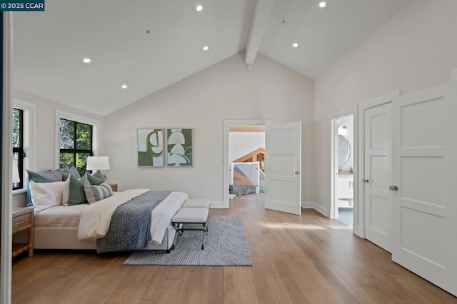 bedroom with high vaulted ceiling, ensuite bathroom, light hardwood / wood-style flooring, and beam ceiling