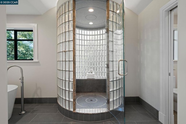 bathroom with walk in shower, lofted ceiling, and tile patterned flooring