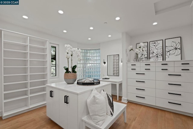 interior space with light hardwood / wood-style floors, white cabinetry, and a center island