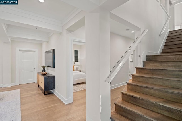 staircase featuring hardwood / wood-style flooring and beamed ceiling