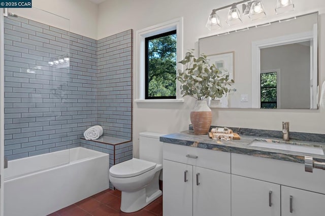 full bathroom featuring vanity, toilet, tiled shower / bath combo, and tile patterned flooring