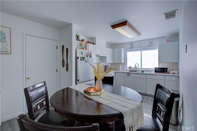 dining room with sink and hardwood / wood-style floors