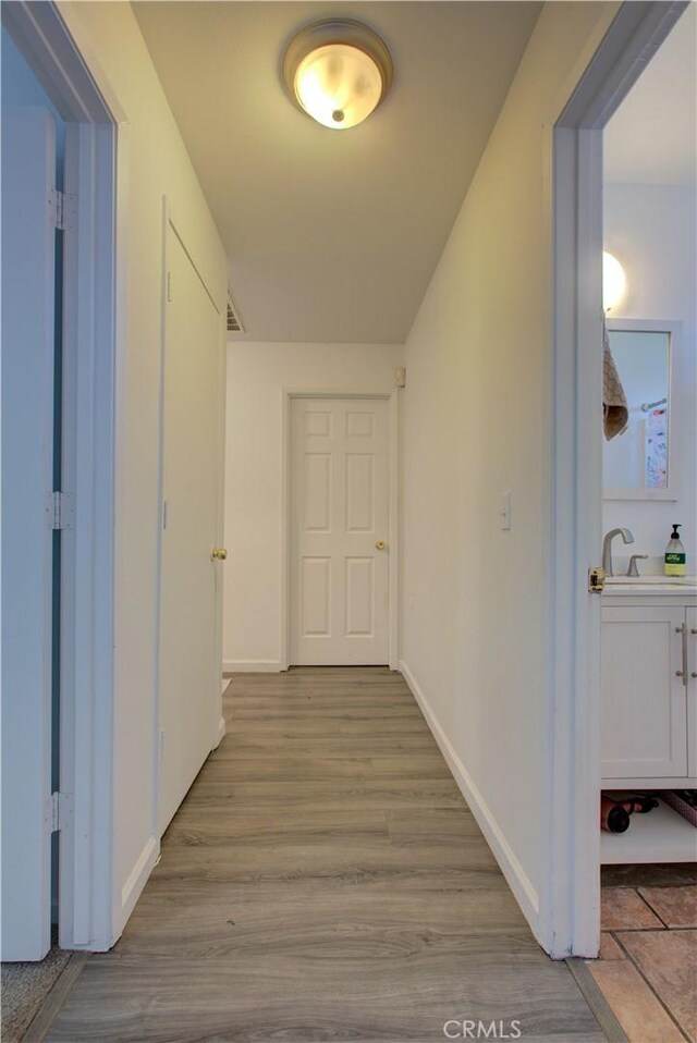 corridor featuring light hardwood / wood-style floors and sink