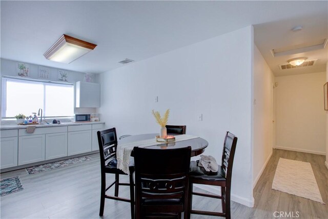 dining room featuring sink and light wood-type flooring