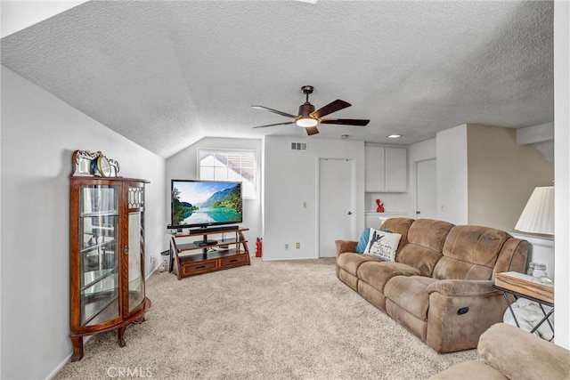 carpeted living room with ceiling fan, a textured ceiling, and lofted ceiling