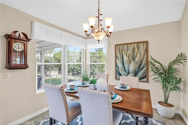 carpeted dining area with an inviting chandelier