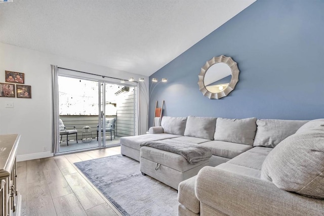 living room featuring vaulted ceiling and light hardwood / wood-style floors