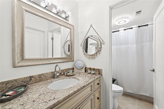 bathroom with vanity, tile patterned flooring, and toilet