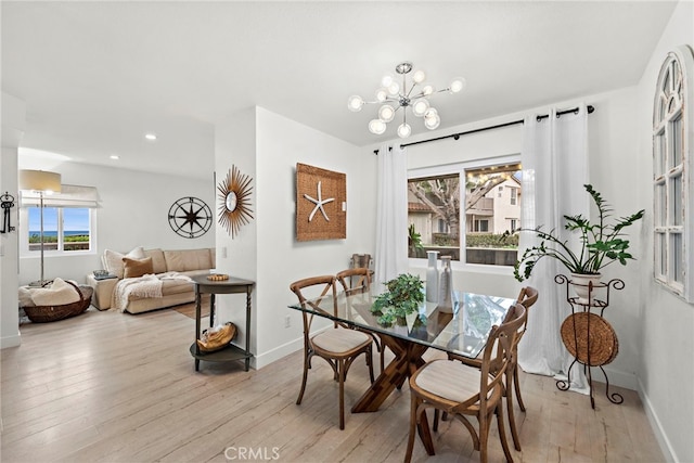 dining space with a notable chandelier and light hardwood / wood-style flooring