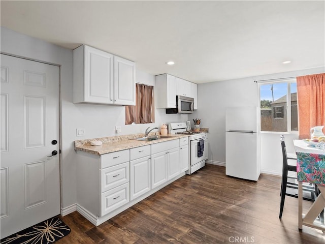 kitchen with sink, white appliances, white cabinetry, and dark hardwood / wood-style flooring